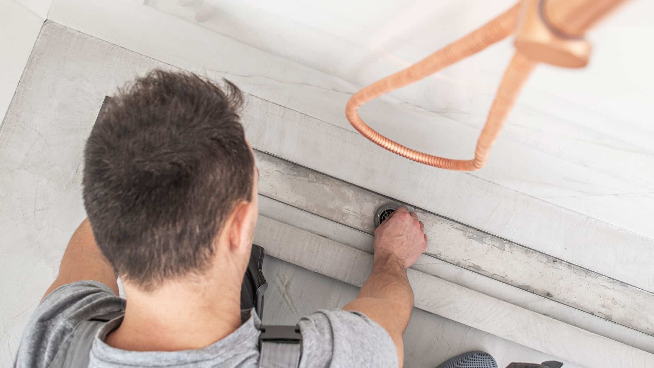 Skilled worker installing bathtub in modern bathroom renovation project.