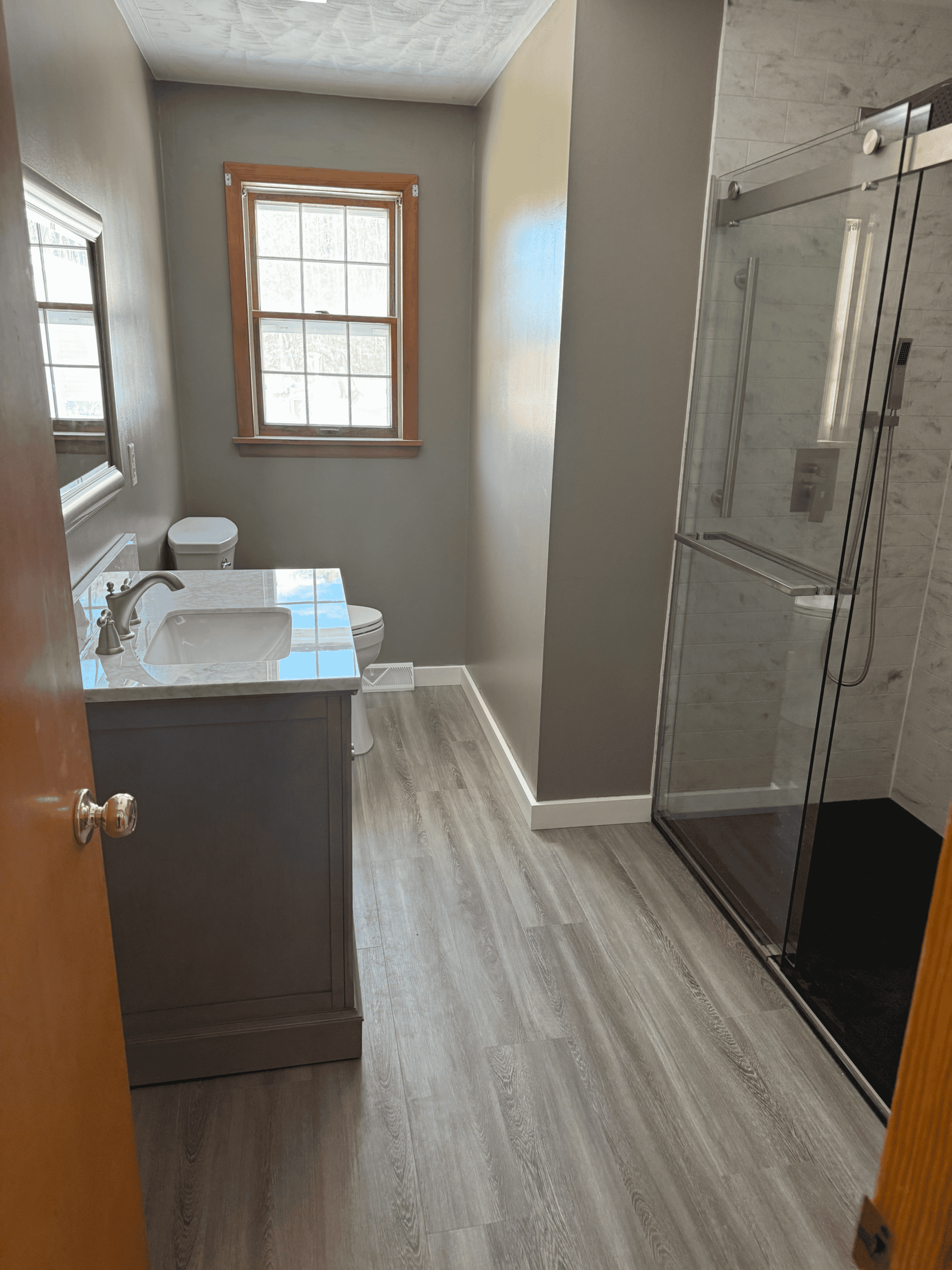 Bright bathroom with a glass shower enclosure and a stylish vanity. Perfect for home upgrades and ba.
