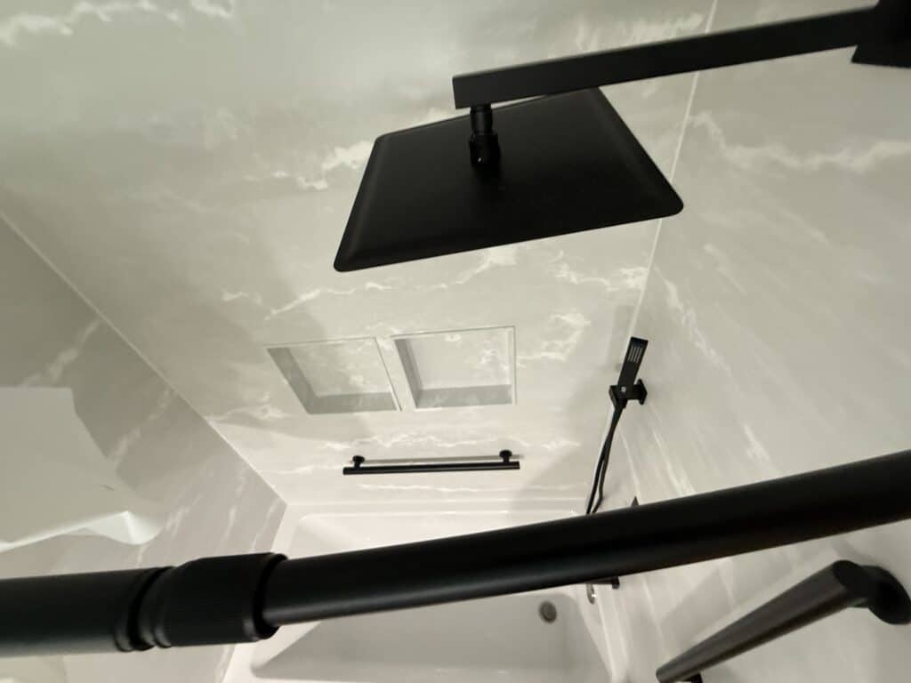 Modern black shower head and fixtures in a sleek bathroom.