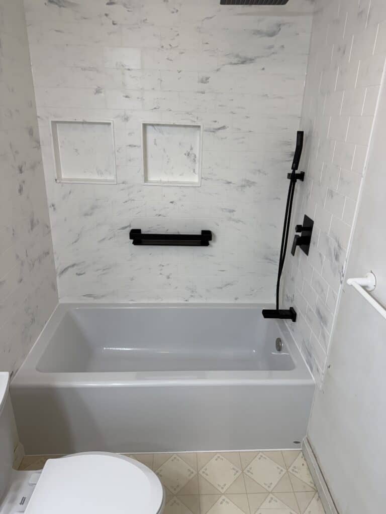 Bathtub with sleek black fixtures in a contemporary bathroom setting.