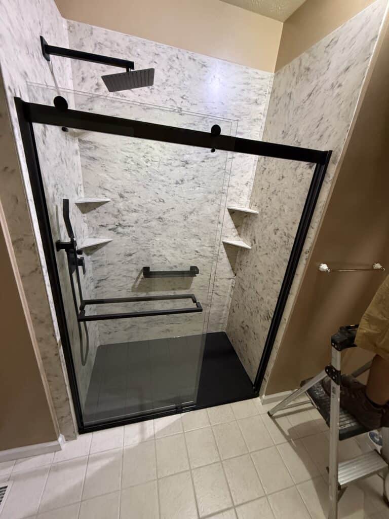 Accessible walk-in shower with grab bars and built-in shelves.