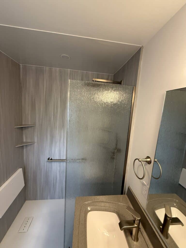 Modern bathroom shower with frosted glass door and sleek design.