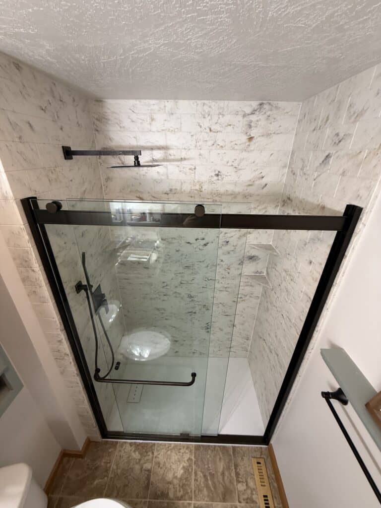 Shower enclosure with glass doors and modern fixtures in a bathroom.