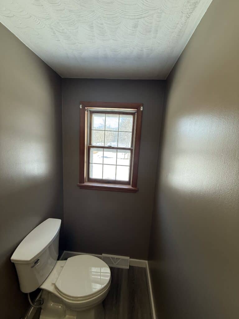 Small bathroom with a window and modern toilet.