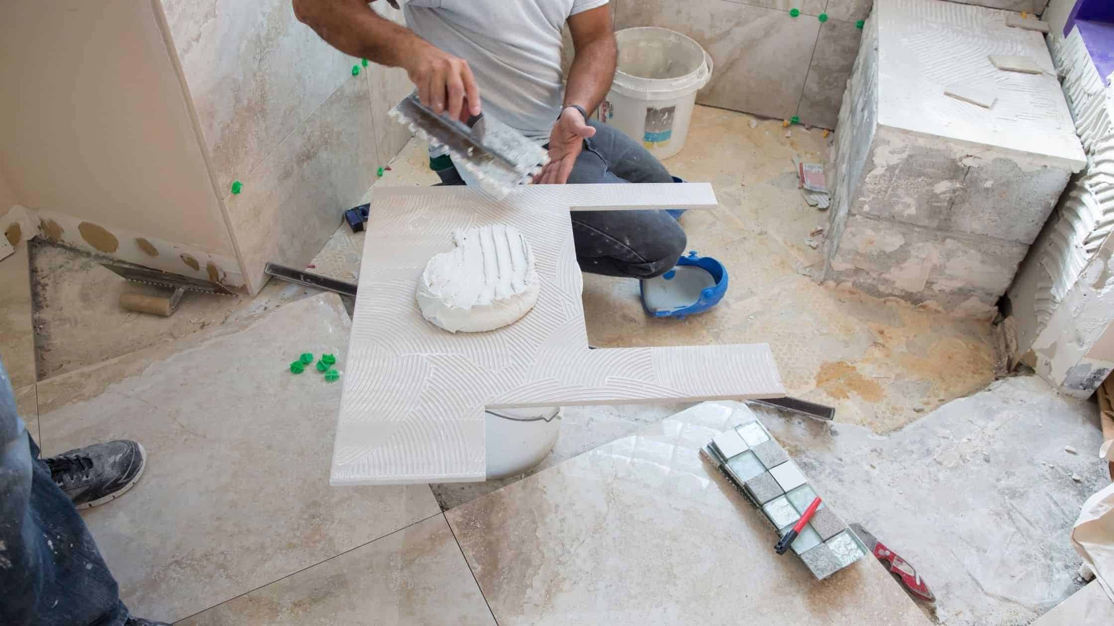 Skilled worker applying tile in a bathroom renovation project for a modern, stylish look.