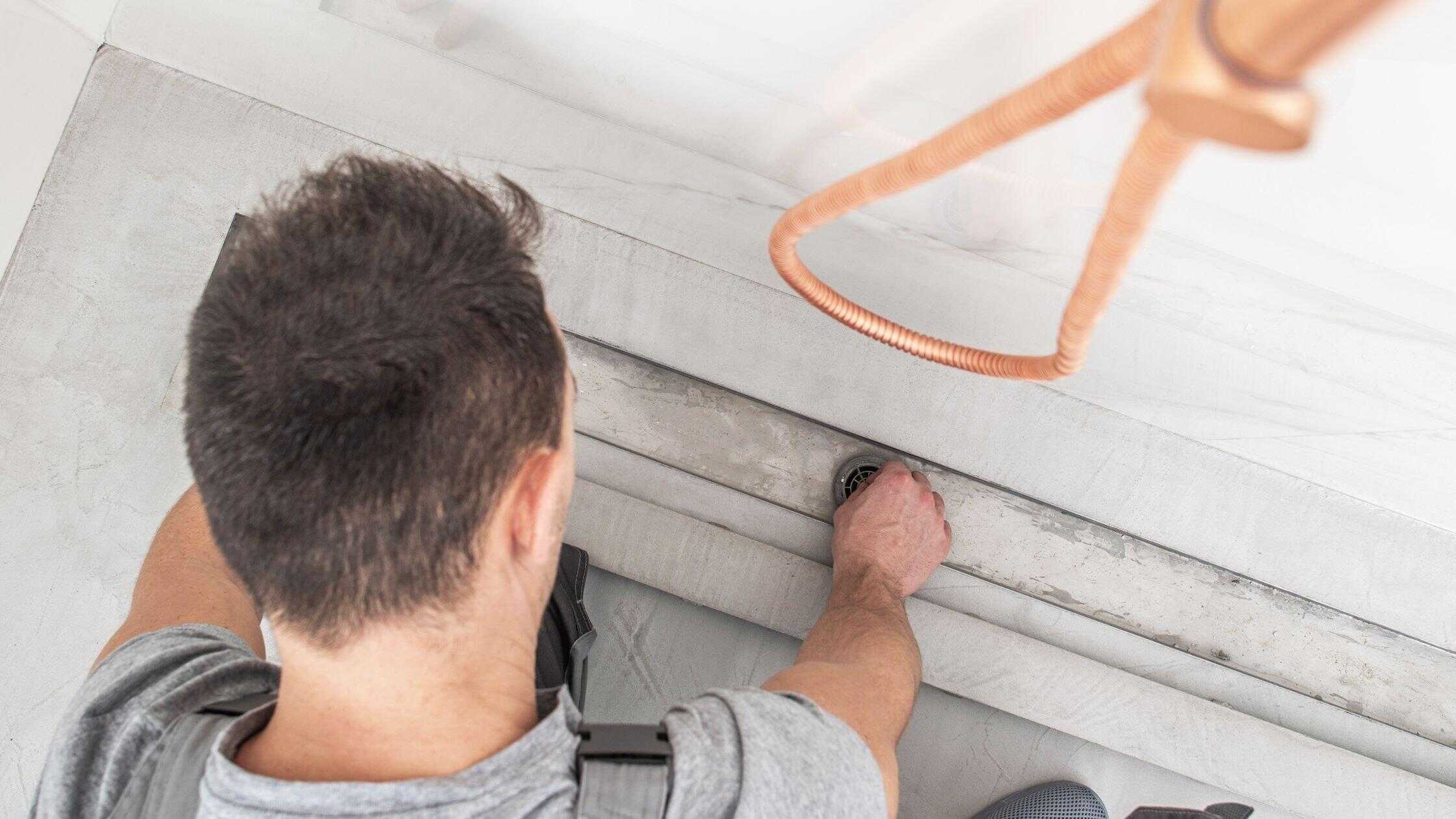 Plumber inspecting and fixing a clogged bathroom sink drain.
