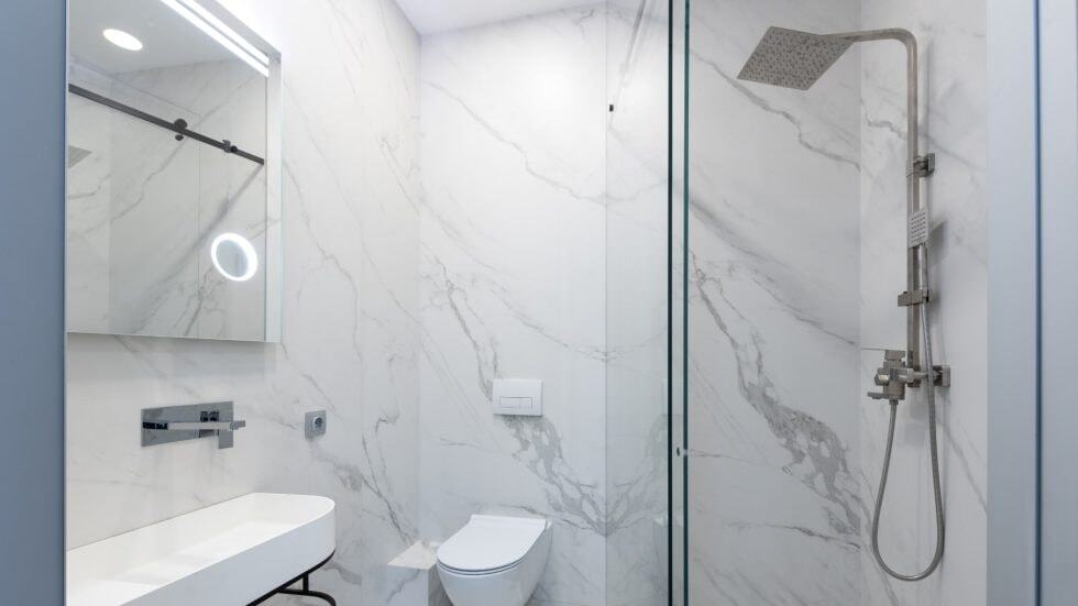 Modern bathroom shower with sleek fixtures and marble walls for a luxurious look.
