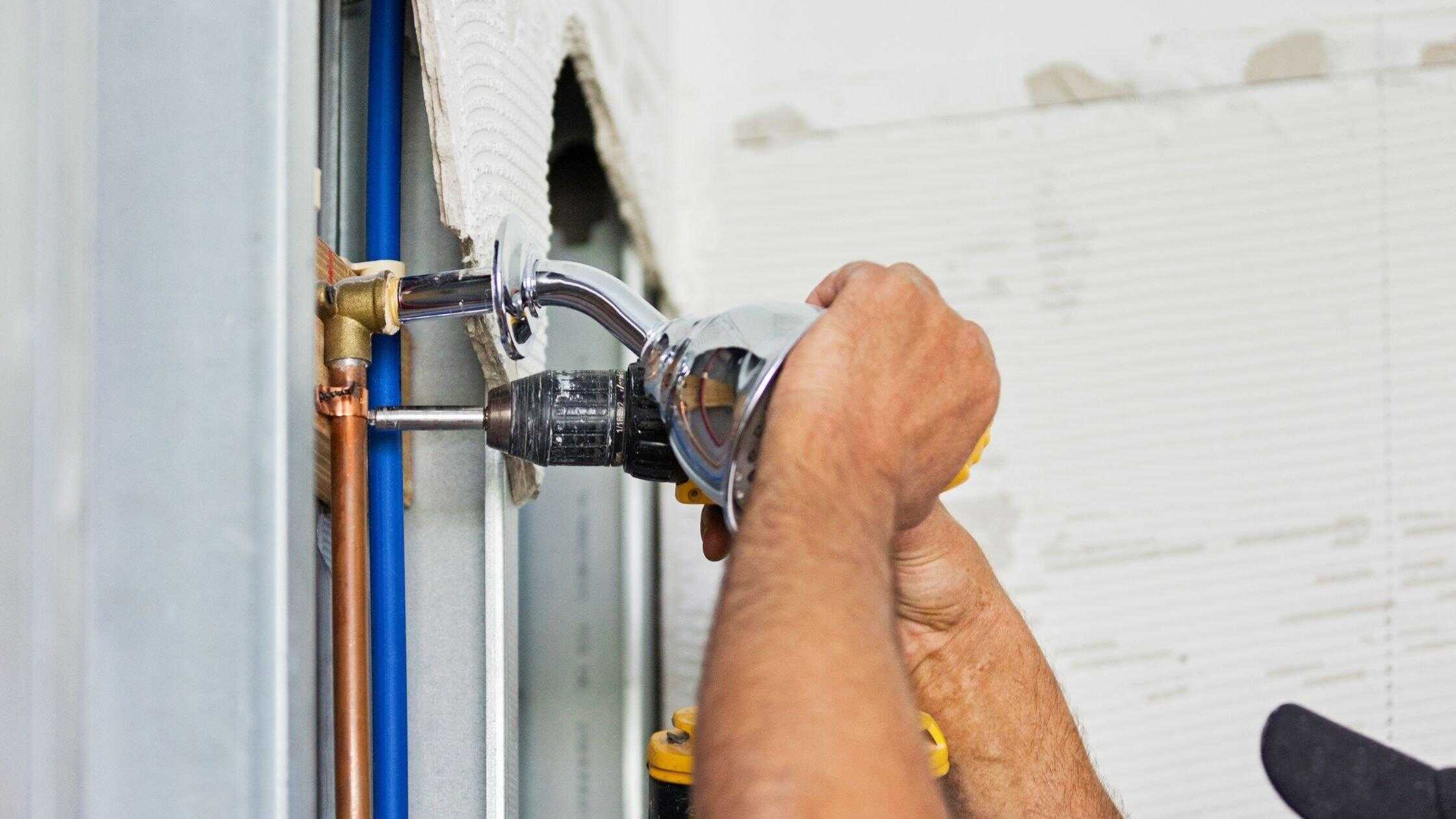 Professional plumbing repair with a technician fixing pipes in a residential bathroom.