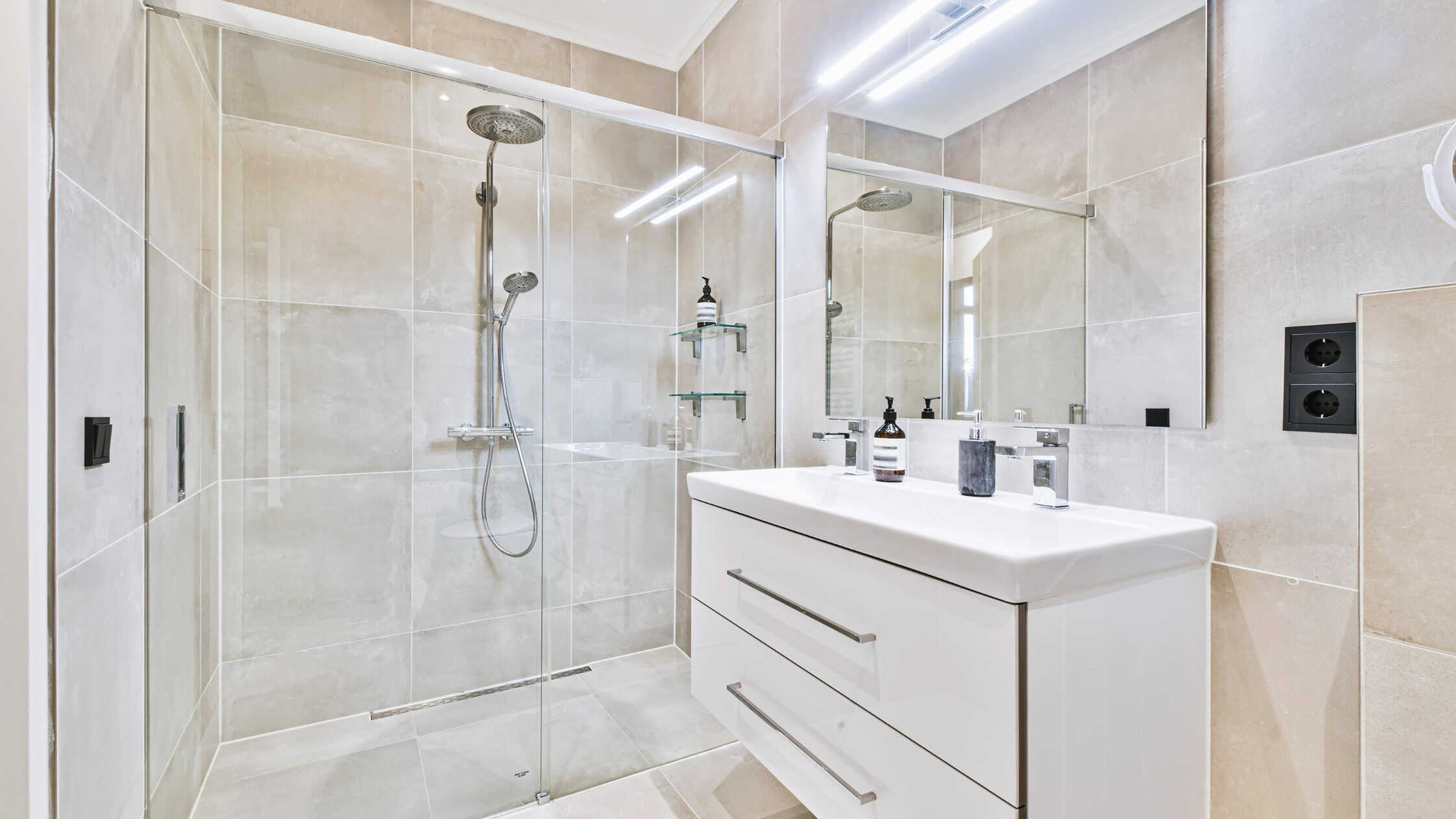 Bright modern bathroom with walk-in shower and sleek vanity.