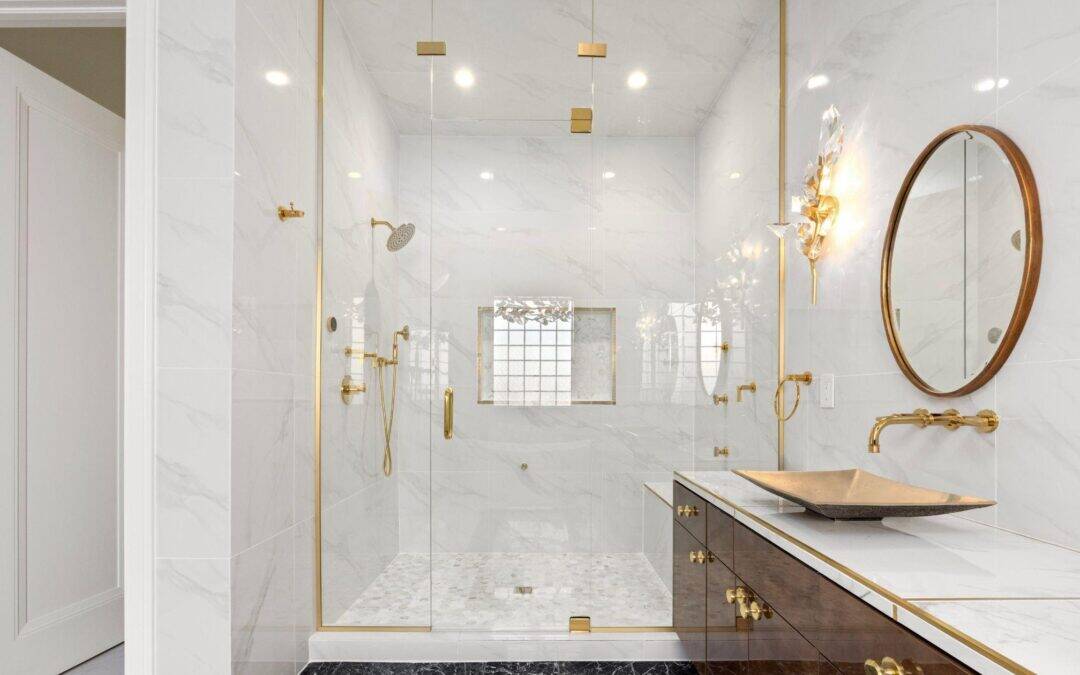 Elegant walk-in shower with gold fixtures and marble accents.